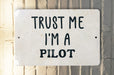 a white sign that says trust me i'm a pilot