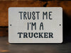 a white sign that says trust me i'm a trucker