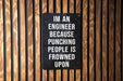 a sign on a wooden wall that says i'm an engineer because punching people