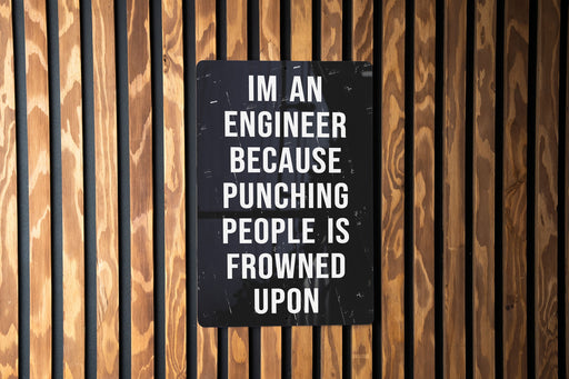 a sign on a wooden wall that says i'm an engineer because punching people
