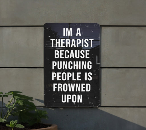 a sign on a wall that says i'm a therapy because punching people is