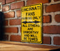 a yellow street sign on a brick wall