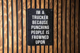 a sign on a wooden wall that says i'm a trucker because punching