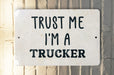 a white sign that says trust me i'm a trucker