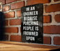 a sign on a brick wall that says i'm an engineer because punching people