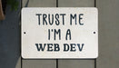 a white sign that says trust me i'm a web dev