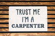 a white sign that says trust me i'm a carpenter