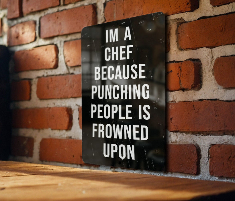 a sign on a brick wall that says i'm a chef because punching people