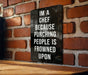 a sign on a brick wall that says i'm a chef because punching people