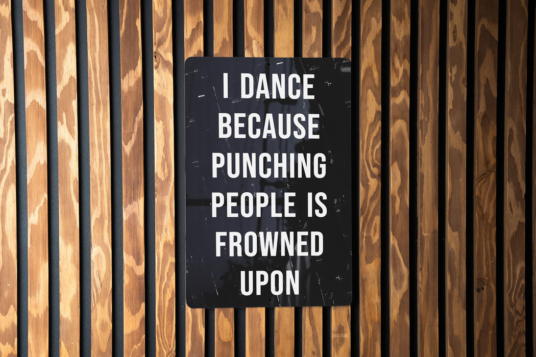 a sign on a wooden wall that says i dance because punching people is frowned