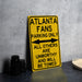a yellow atlanta fans parking only sign next to a white plate