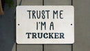 a white sign that says trust me i'm a trucker