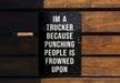 a sign on a wooden bench that says i'm a trucker because punching