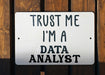a white sign that says trust me i'm a data analist