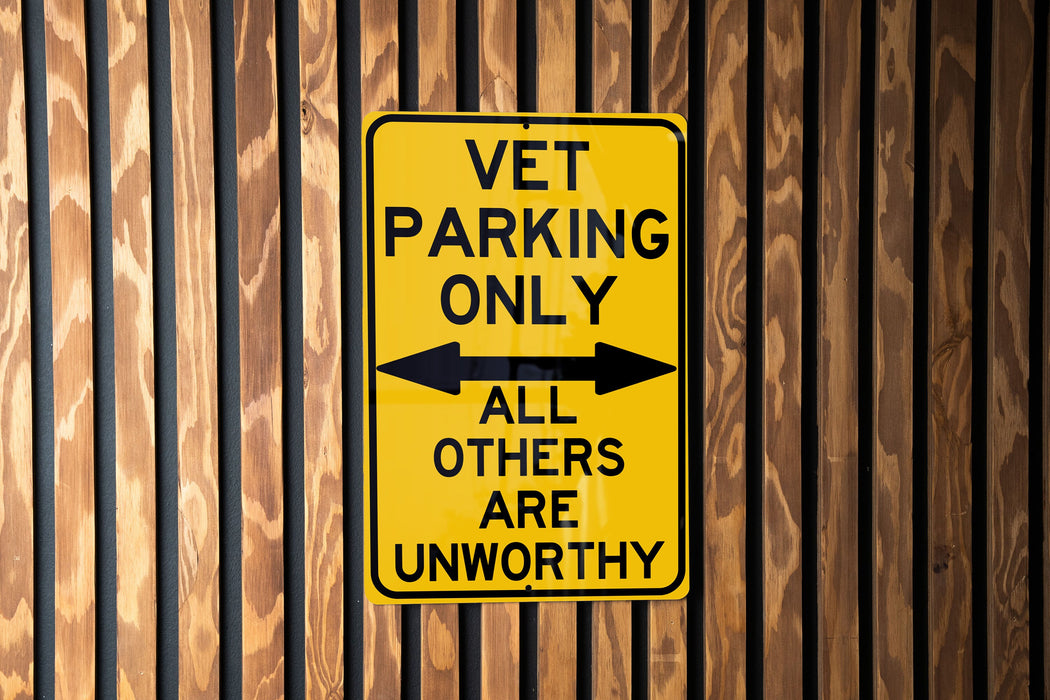 a yellow sign that says vet parking only all others are unworthyly