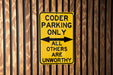 a yellow parking only sign on a wooden fence