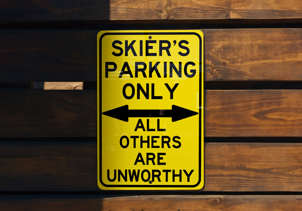 a yellow parking only sign hanging on a wooden wall