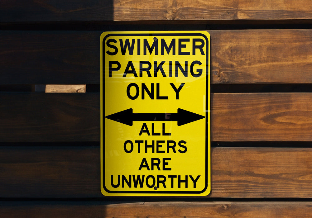a yellow swimming only sign hanging on a wooden wall