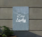 a sign that says dog lady next to a potted plant