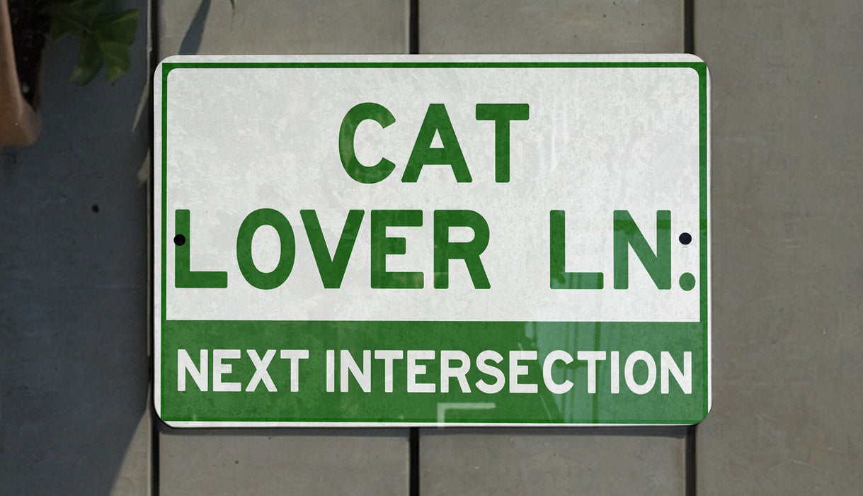 a green and white sign that says cat lover ln next intersection