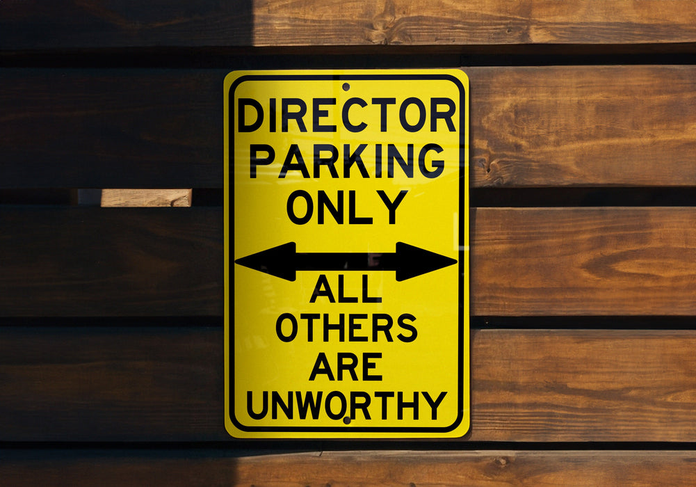 a yellow sign that says director parking only all others are unworthyly