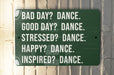 a green sign that says bad day? dance good day? dance stressed?