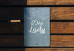 a sign that reads dog lady on a wooden bench