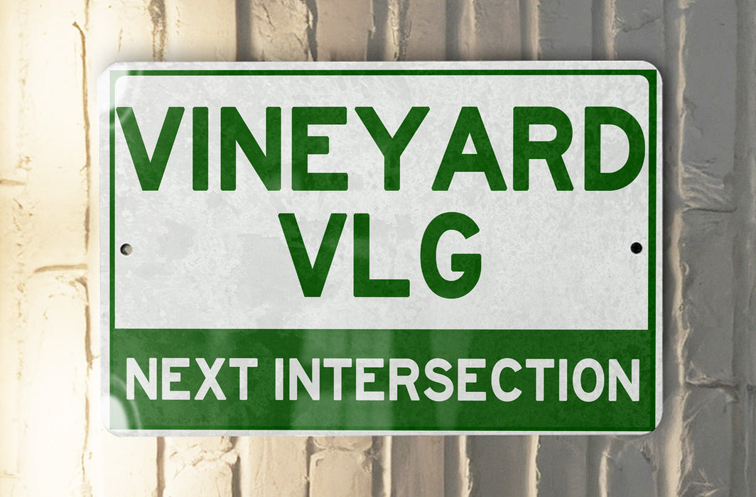 a green and white sign that says vineyard vlg next intersection
