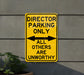 a yellow sign that says director parking only all others are unworthyly