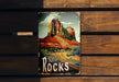 a metal sign that reads red rocks on a wooden bench