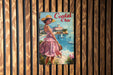 a poster of a woman in a pink dress on a wooden wall