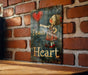 a sign on a brick wall that says teach heart