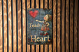 a sign on a wooden wall that says teach heart