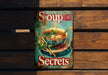 a sign advertising soup on a wooden wall