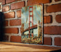 a picture of a golden gate bridge on a brick wall