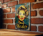 a picture of a woman's face on a sign on a brick wall