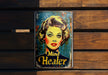 a metal sign with a woman's face painted on it