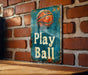 a sign on a brick wall that says play ball