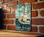 a picture of a sailboat on a sign on a brick wall