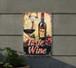a metal sign with a bottle of wine and a glass of wine