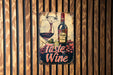 a wine sign hanging on the side of a wooden wall