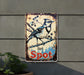 a metal sign with a bird sitting on a branch