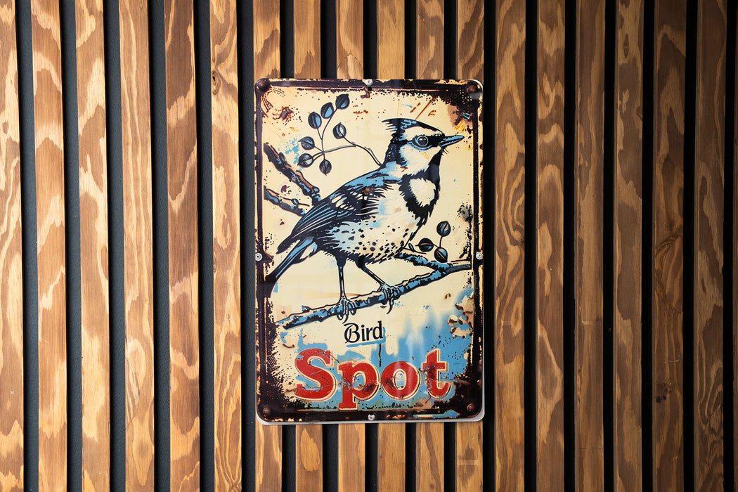 a blue bird sitting on top of a wooden sign