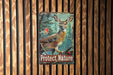 a picture of a deer and a bird on a wooden wall