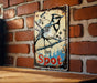 a bird sits on a sign on a brick wall