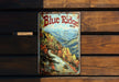 a blue ridge cigarette tin sitting on top of a wooden bench