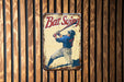 a metal sign with a baseball player holding a bat