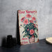 a flower nursery sign next to a vase of flowers