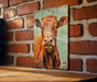 a picture of a cow on a brick wall
