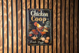 a chicken coop sign hanging on a wooden wall